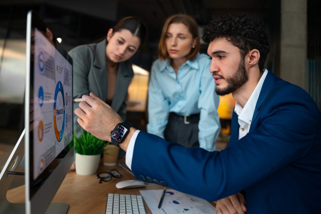 Team reviewing sales data on screen during sales training for employees in a modern office setting