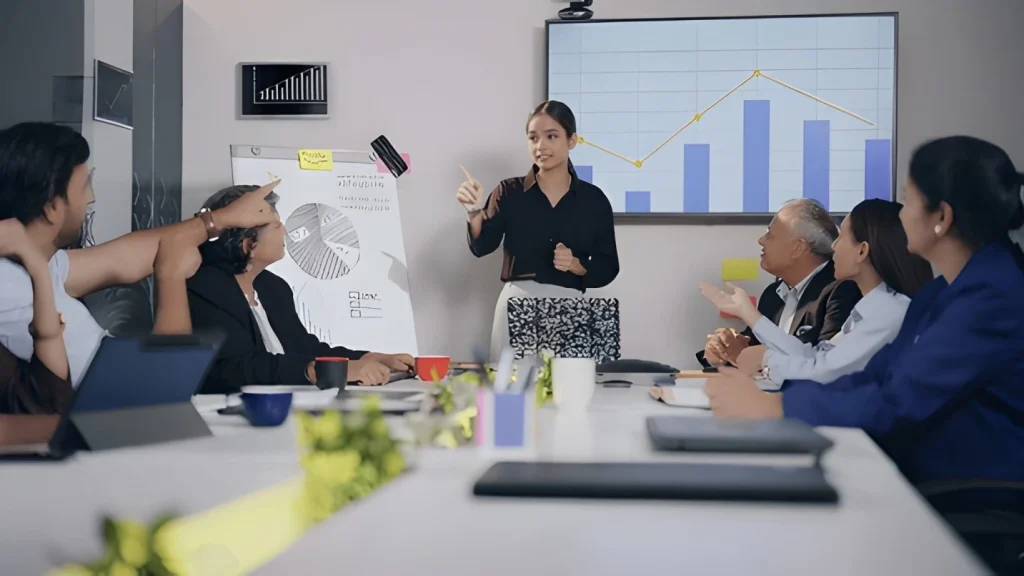 Team meeting with businesswoman presenting growth chart and data analysis.