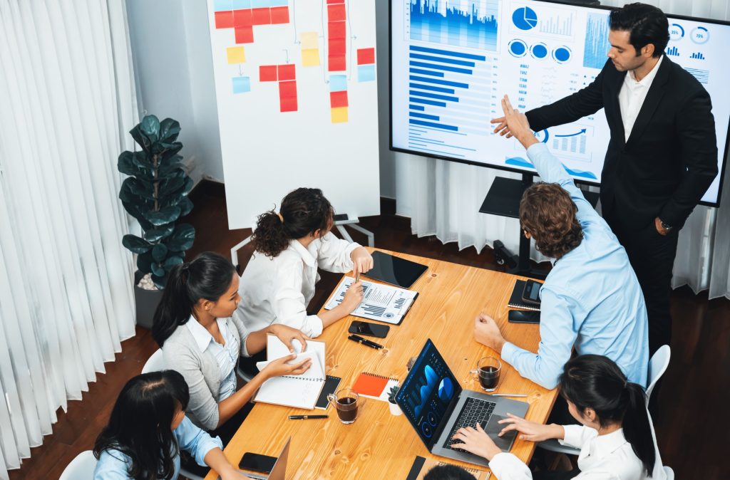 Corporate team discussing sales charts during a customized sales training in Delhi.